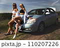 skinny girls are relaxing near a broken car away from the bustle of the city, best friends are free and enjoy the journey. High quality photo 110207226