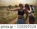 an accident on the road, a car broke down, two beautiful girl models are hitchhiking a car. Showing the thumb up. Problem with the car. Friends waiting for service. In the countryside . High quality 110207228