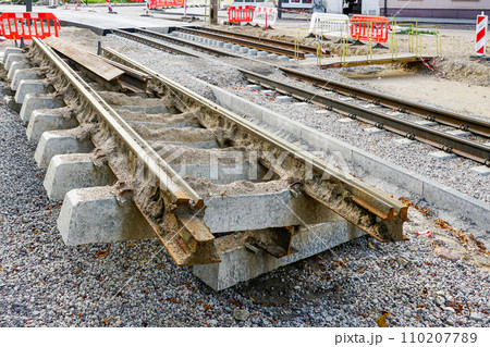 Old cut out tram track fragment with concrete sleepers, tram rails replacement in city street Old cut out tram track fragment with concrete sleepers, tram rails replacement in city street 110207789