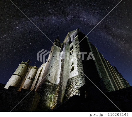 Mont Saint-Michel night view.  Built in the XI-XVI centuries. The main facade of the church  built in the 12th century. Architect  William de Volpiano. Starry sky with Milkyway above. 110208142