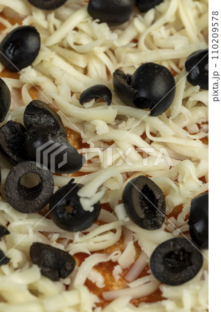 pizza dough with cheese and meat and olives 110209578