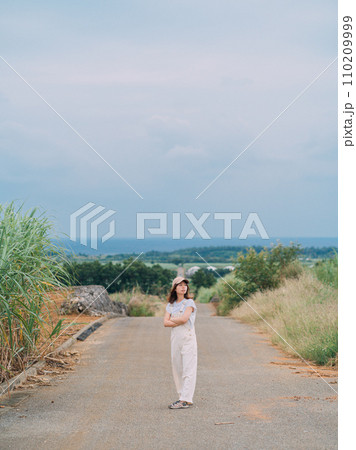 海へ続くさとうきび畑を歩く女性 海へ続くさとうきび畑を歩く女性 110209999