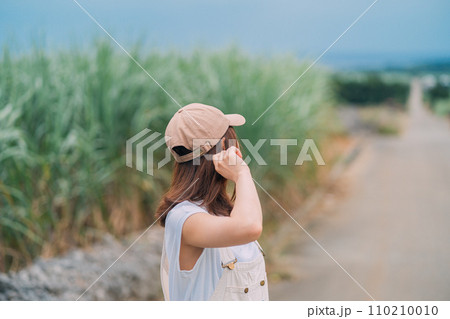 海へ続くさとうきび畑を歩く女性 海へ続くさとうきび畑を歩く女性 110210010