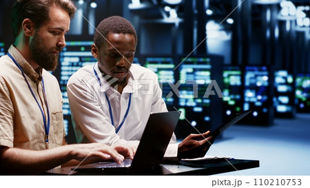 Teamworking experts doing maintenance on servers helping businesses manage databases, host websites and store files. Engineers monitoring supercomputers used for high performance computing 110210753