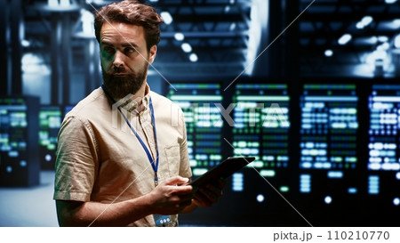 Technician in high tech facility using renewable hydro energy sources to power cryptocurrency farming operations. Specialist working with eco friendly server rigs preventing environmental impact 110210770