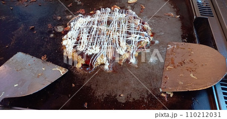 自分で焼いたお好み焼きをヘラと共に 自分で焼いたお好み焼きをヘラと共に 110212031