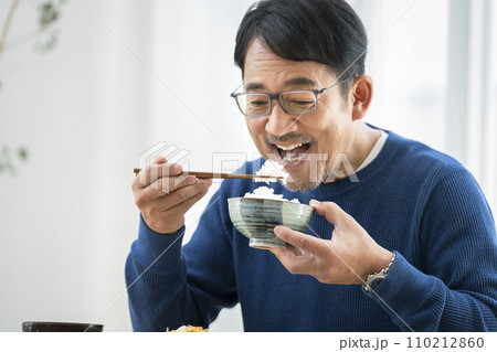ごはんを食べる50代半ばの男性 ごはんを食べる50代半ばの男性 110212860