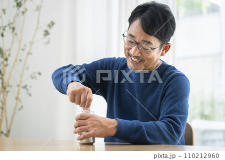 缶ビールを開ける中年男性 110212960