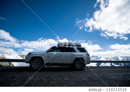 Driving car on snowing high altitude mountain trail, China 110213520