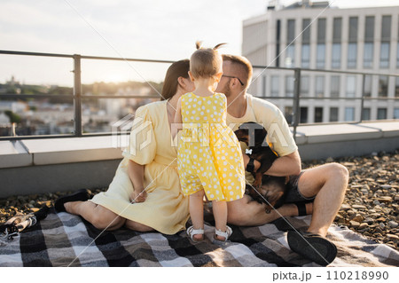 Couple sitting on roof while baby standing before faces 110218990