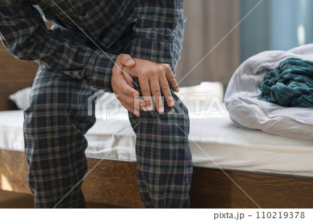 膝をおさえる中年男性の手元 膝をおさえる中年男性の手元 110219378