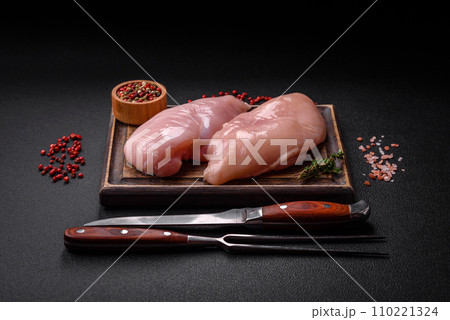 Fresh chicken fillet on a dark concrete table with spices and herbs 110221324