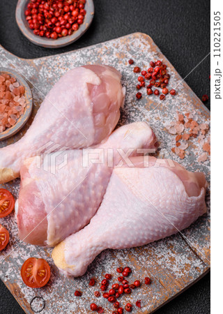 Raw chicken legs with salt, spices and herbs on a dark concrete background 110221505