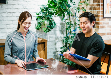 スポーツジムで入会申し込みをする女性 110224024
