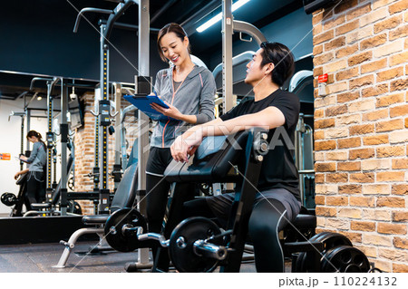 フィットネスジムでトレーナーの指導を受ける男性 フィットネスジムでトレーナーの指導を受ける男性 110224132