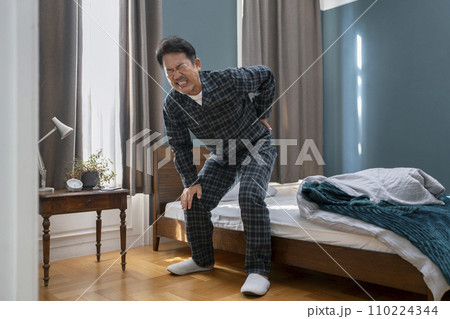 パジャマ姿の中高年男性 腰痛・ぎっくり腰 イメージ パジャマ姿の中高年男性 腰痛・ぎっくり腰 イメージ 110224344