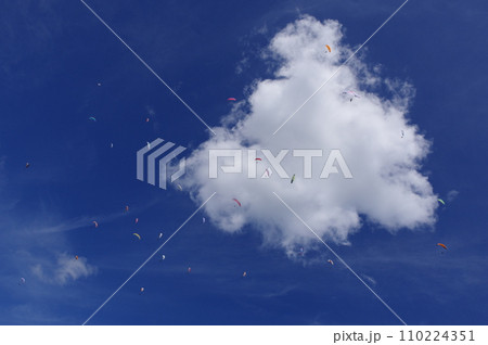 青空に浮かぶ白い雲と空に舞うパラグライダー 青空に浮かぶ白い雲と空に舞うパラグライダー 110224351