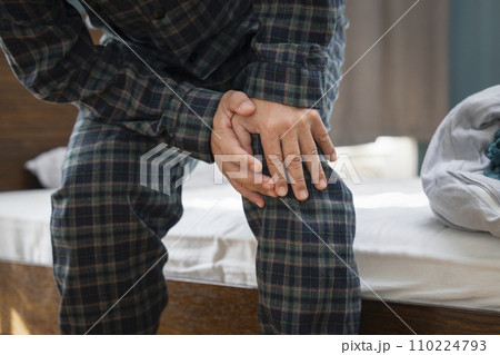 膝をおさえる中年男性の手元 膝をおさえる中年男性の手元 110224793