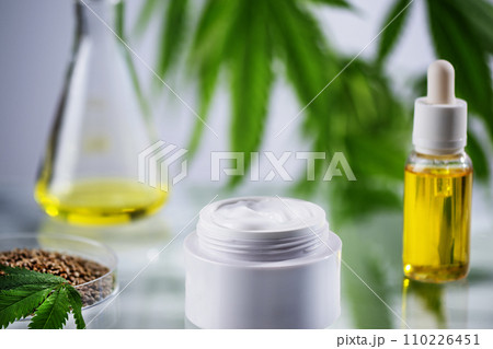 Herbal hemp cream and cbd oil with cannabis leaf and seed in laboratory. Cannabis sativa cosmetic for body care. Herbal hemp cream and cbd oil with cannabis leaf and seed in laboratory. Cannabis sativa cosmetic for body care. 110226451