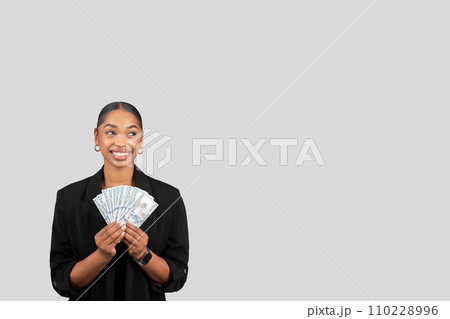 Happy pretty young african american lady in formal suit show many money dollars Happy pretty young african american lady in formal suit show many money dollars 110228996