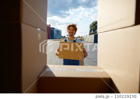 Young warehouse worker holding clipboard box unloading delivery truck car Young warehouse worker holding clipboard box unloading delivery truck car 110229230