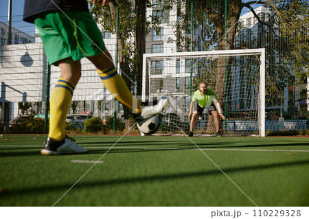 Football player aiming soccer ball trying to score goal 110229328