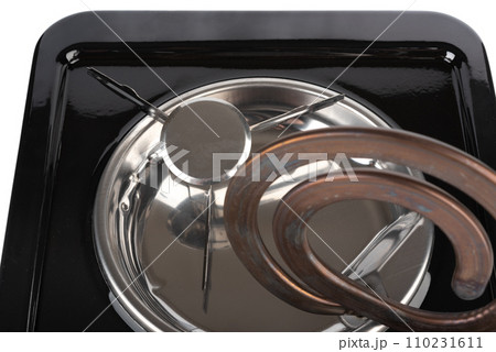 Close-up of the heating element of a tabletop electric stove raised for cleaning. 110231611