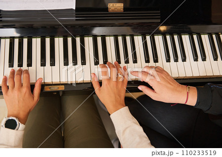 Young woman with student playing piano, above view. Music lesson 110233519
