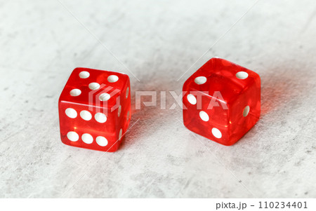 Two translucent red craps dices on white board showing Natural or Seven Out (number 5 and 2) 110234401