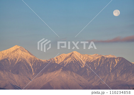 【月素材】冬の朝焼けした北アルプスと満月【長野県】 110234858