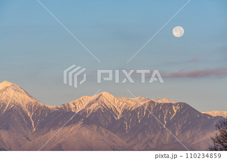 【月素材】冬の朝焼けした北アルプスと満月【長野県】 110234859