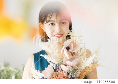 ドライフラワーの花束を持つワンピースの女性 110235308
