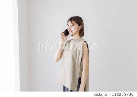 スマートフォンで話す若い女性 110235730