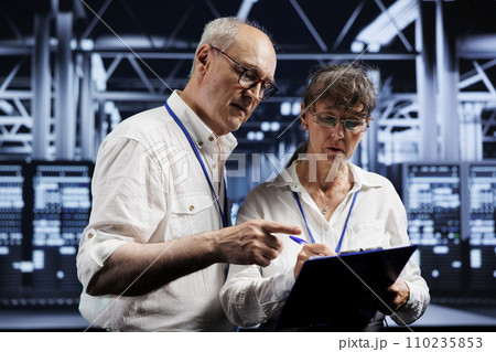 Technical support consultants fixing server system failures. Old mechanics brainstorming ideas on how to best minimize high tech data storage business downtime and prevent damage Technical support consultants fixing server system failures. Old mechanics brainstorming ideas on how to best minimize high tech data storage business downtime and prevent damage 110235853