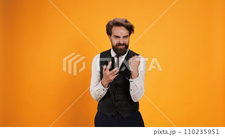 Happy waiter reads news on phone and feeling pleased on camera, preparing to serve consumers. Modern elegant butler with tie using smartphone to stay connected, social media app. 110235951