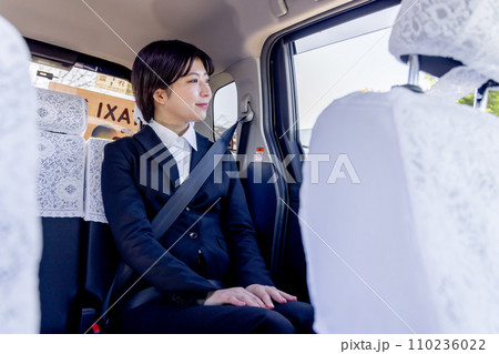 タクシーの後部座席に座るビジネスウーマン 110236022