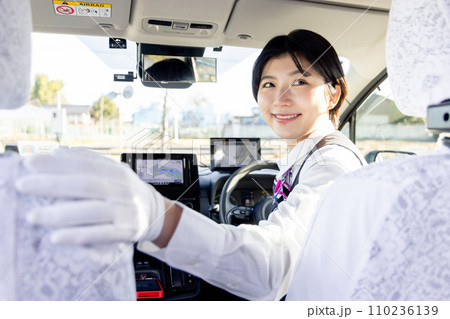 後方確認をする女性のタクシードライバー 後方確認をする女性のタクシードライバー 110236139