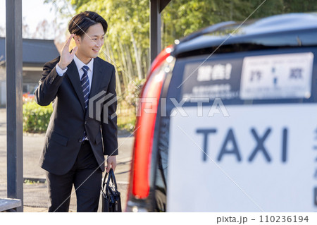 タクシーを呼び止めるビジネスマン 110236194