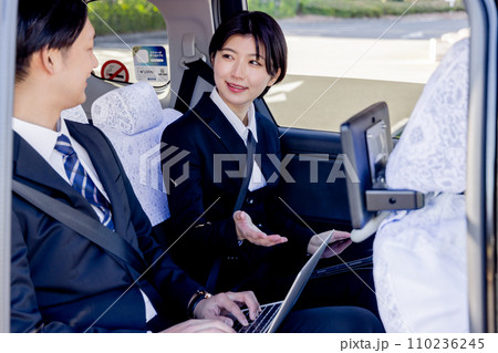 タクシーの後部座席で打合せをするビジネスマン 110236245