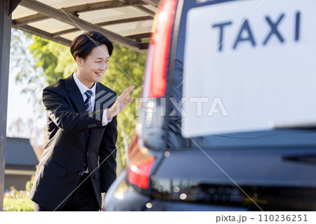 タクシーを呼び止めるビジネスマン 110236251
