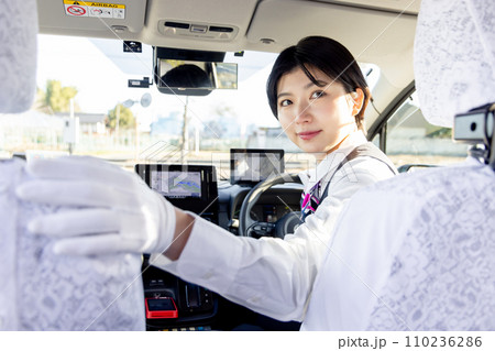 後方確認をする女性のタクシードライバー 後方確認をする女性のタクシードライバー 110236286