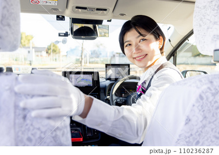 後方確認をする女性のタクシードライバー 後方確認をする女性のタクシードライバー 110236287
