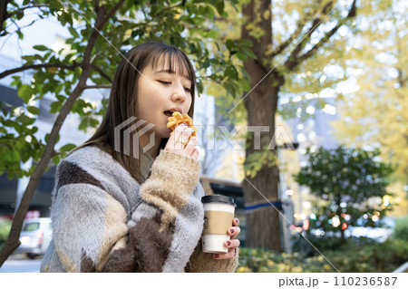 屋外でワッフルを食べる女性 110236587