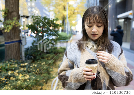 屋外でホットコーヒーを持つ女性 110236736