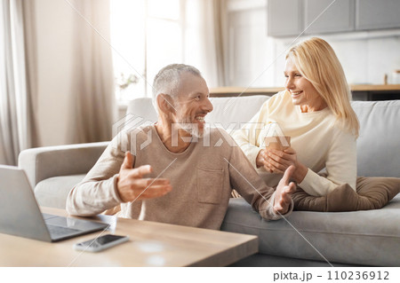 Cheerful senior couple using computer at home Cheerful senior couple using computer at home 110236912