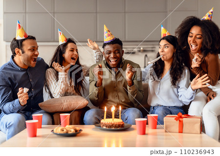 Happy multiracial students celebrating birthday of black guy in kitchen 110236943