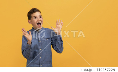 Amazed Teen Boy Looking At Copy Space And Raising Hands In Excitement Amazed Teen Boy Looking At Copy Space And Raising Hands In Excitement 110237229
