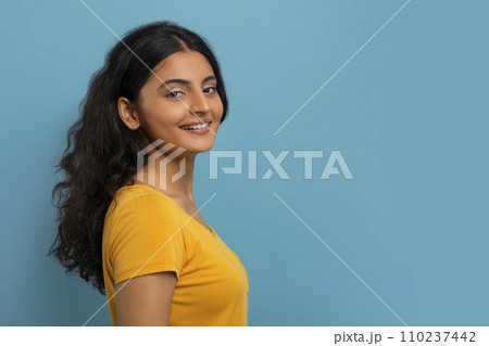 Profile portrait of attractive young indian woman posing on blue Profile portrait of attractive young indian woman posing on blue 110237442