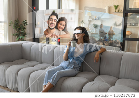 lady wearing virtual reality glasses connecting remotely with family indoors 110237672