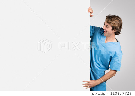 Cheerful nurse peeks from side, medical ad concept 110237723